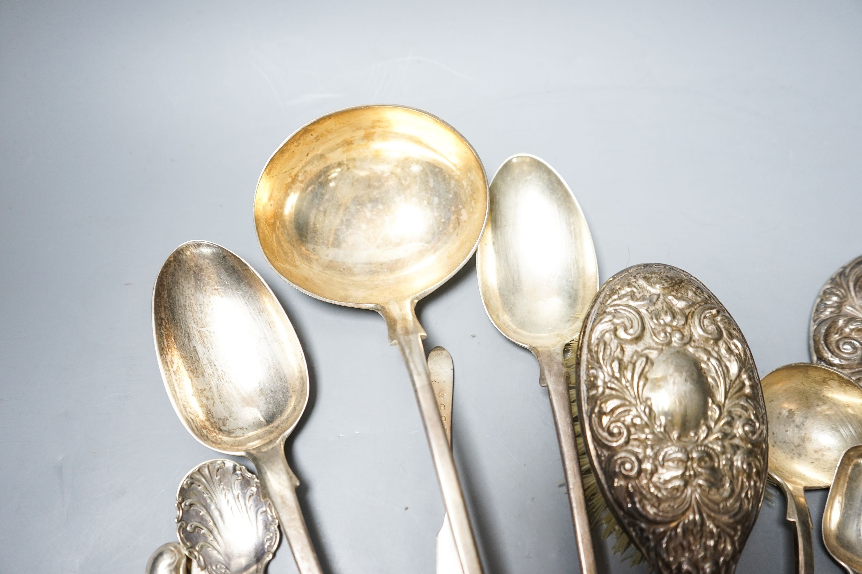 A group of silver flatware including a Victorian soup ladle and two basting spoons and three dressing table accessories, weighable silver 24oz